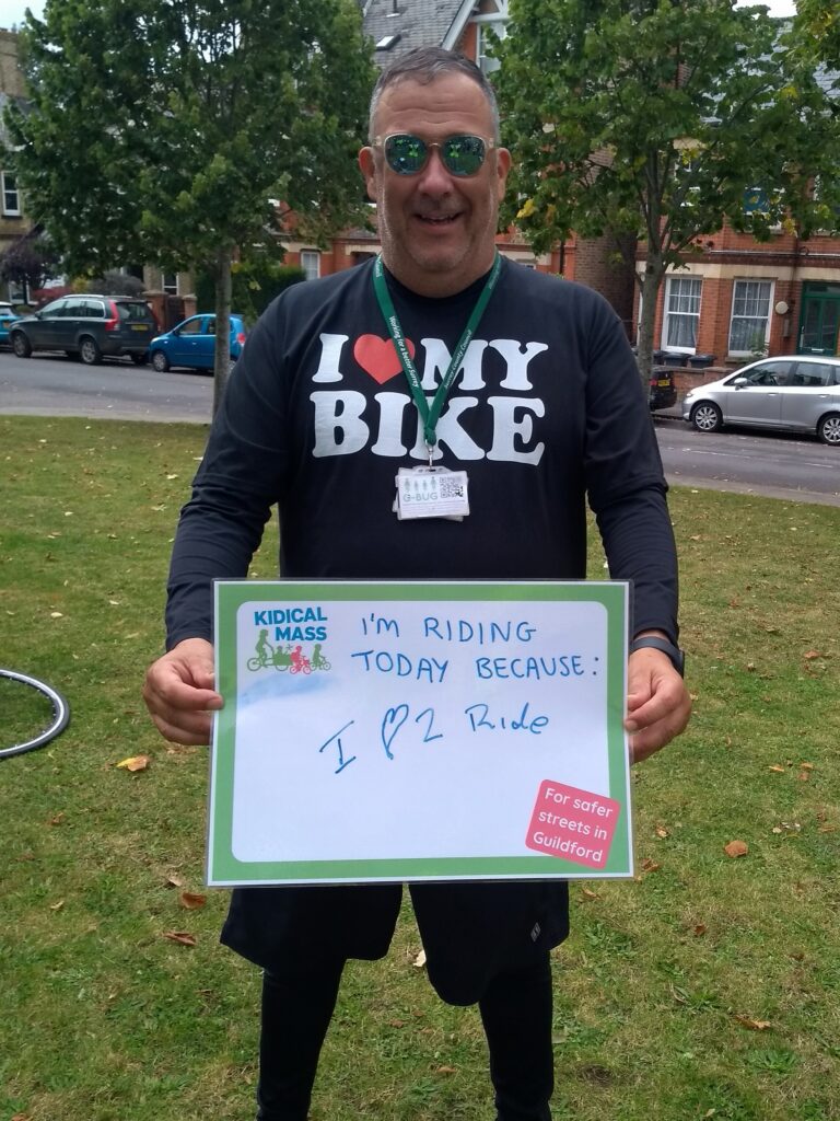 Photo of Cllr Paul Deach holding a sing which says "I'm riding today because I love to ride"
